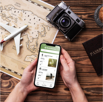 Traveler planning a trip on a mobile travel app next to map, passport, and camera while researching destinations and tours.