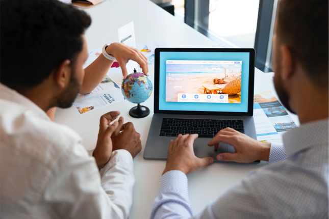 Travel marketing team reviewing a tourism website on a laptop while planning SEO and link building strategies.